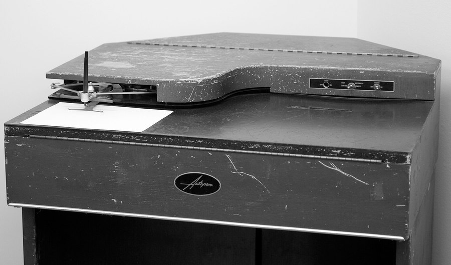 Autopen signature machine, institutional model in a metal cabinet, with articulated arm and sheet positioned under the pen